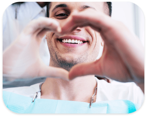 Smiling dental patient making a heart shape