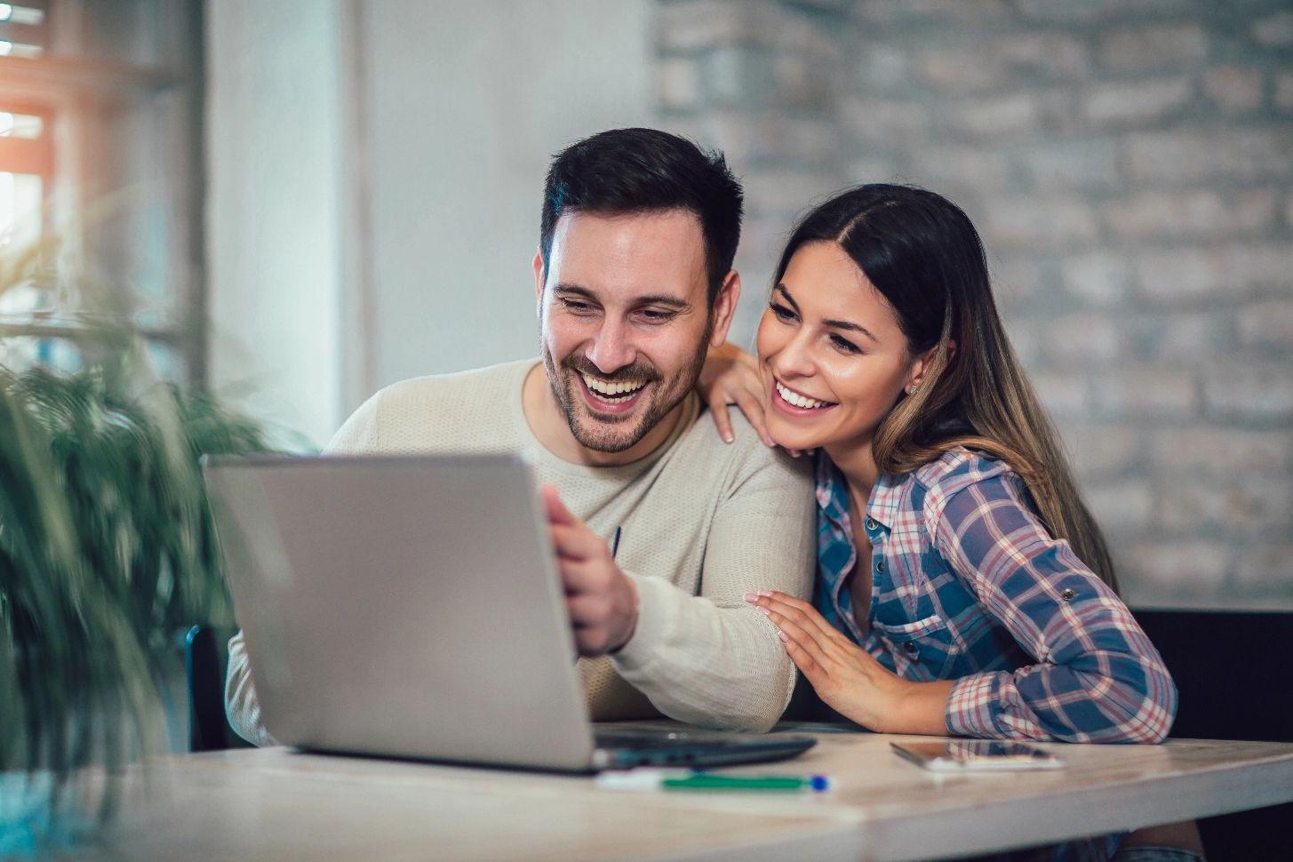 Smiling couple reviewing financing options on a laptop